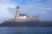Long point lighthouse appearing out of the mist off White Head Island near Grand Manan Island Canada August 2016
