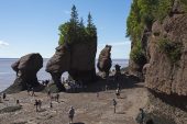 Rocks and visitors on the ocean floor at the edge of the bay of Fundy Hopewell Rocks New Brunswick Canada August 2016