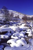 Fresh snow on boulders in the Claerwen River Claerwen Valley Powys Wales