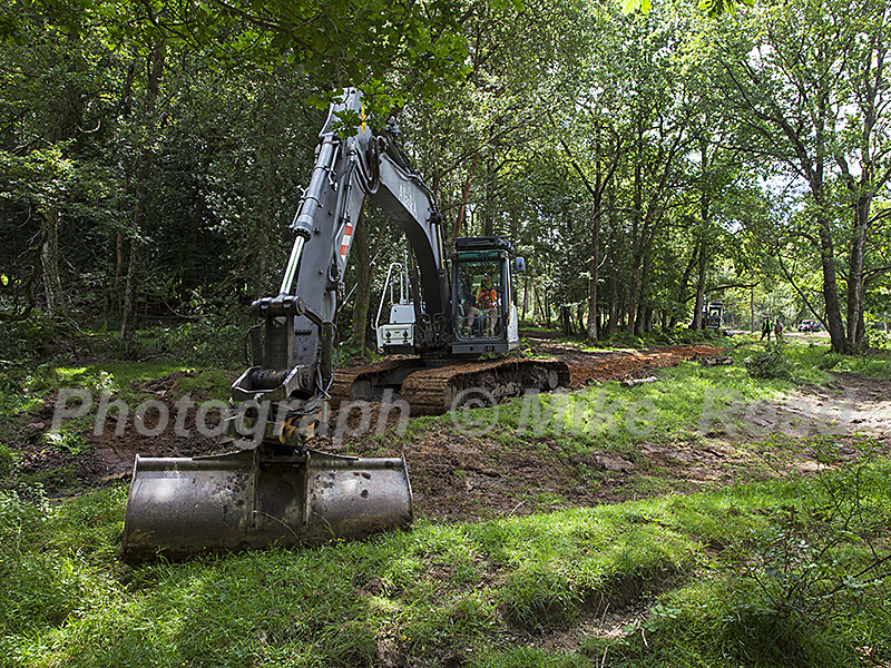 Digger involved in stream restoration work Wootton New Forest National Park Hampshire England UK August 2016